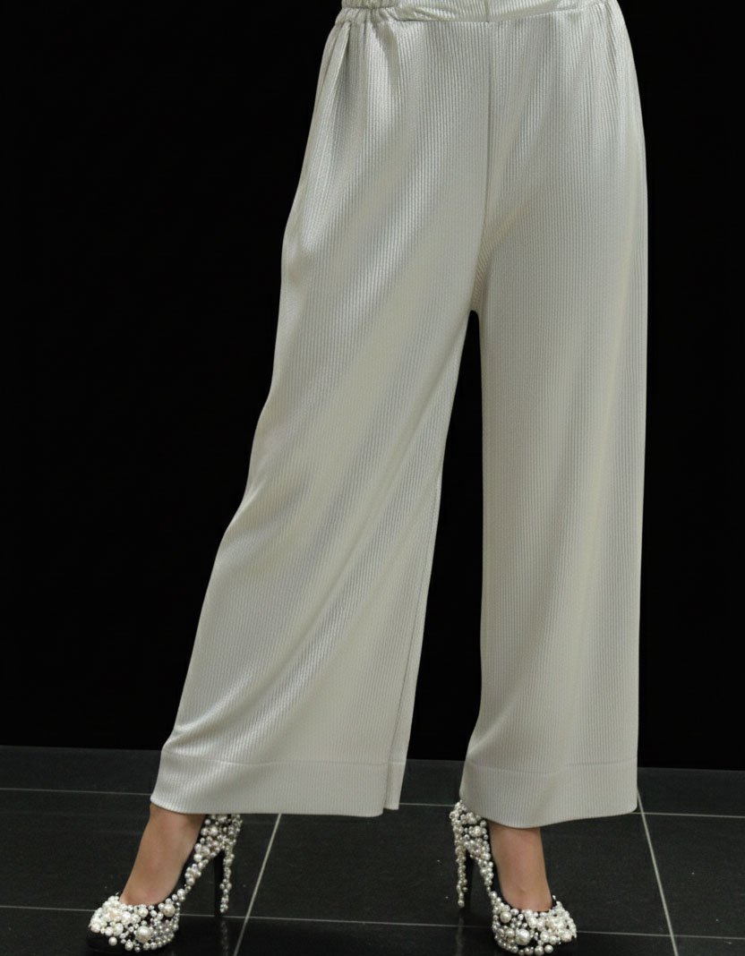 High-fashion studio shot for Asmar Poshak featuring a pair of off-white, pleated wide-leg trousers