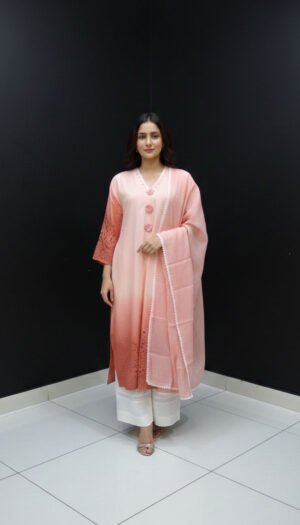 Peach Ombré Chikankari Masterpiece, a stunning 3-piece lawn ensemble featuring a gradient peach kurta with chicken kari sleeves, exquisite cut-dana work on the neck with fancy flower buttons, paired with a lace-bordered lawn dupatta and white lace-hemmed palazzo pants.,