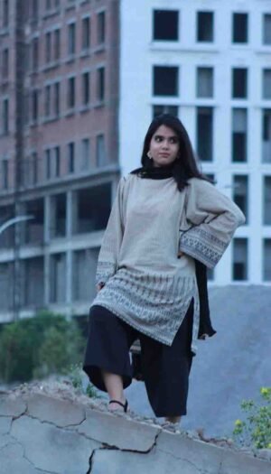 wearing Graphite Grid Lawn a beige and black patterned 3-piece lawn suit with a black dupatta and wide-leg trousers.